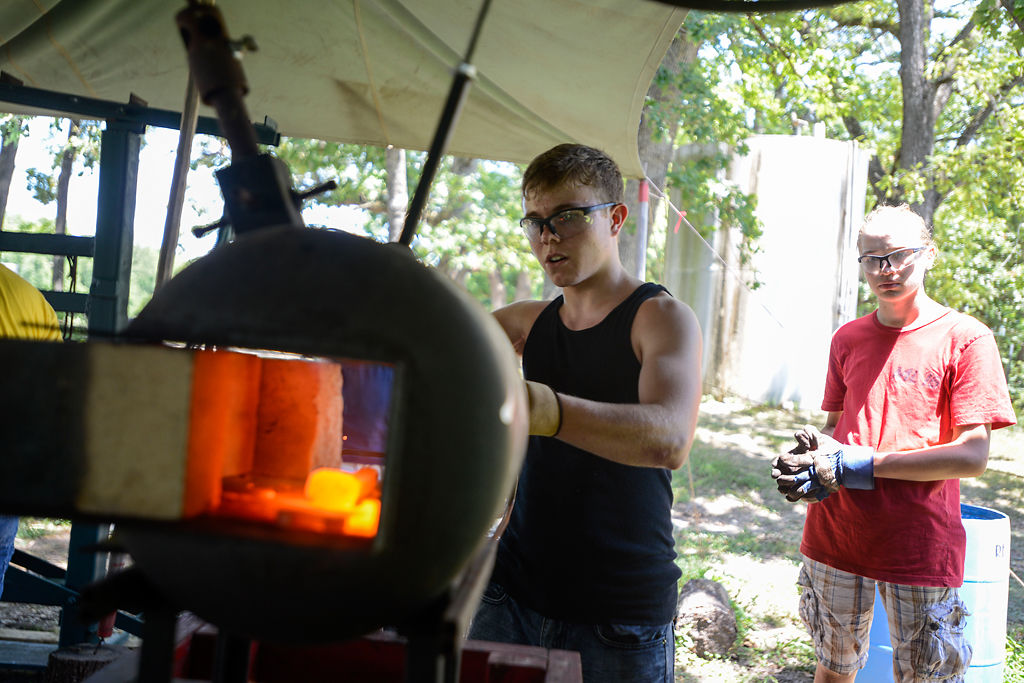 Brad Snyder removes a piece of metal from a furnace